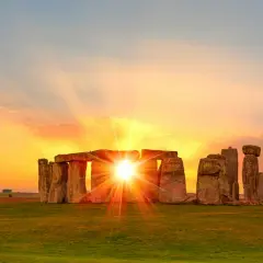 Solens strålar bryter igenom Stonehenge, en magisk syn för att fira vintersolståndet.