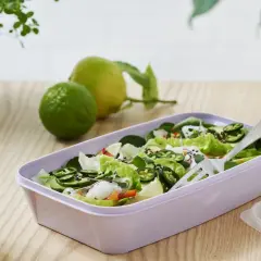 En fräsch sallad med gröna blad, jalapeños och avokado i en lila matlåda. Perfekt för **organisk mat** på språng.