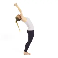 Kvinna i urdhva dhanurasana, en bakåtböjning med armarna sträckta uppåt. Hennes flätade hår faller bakåt.