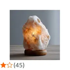 En vacker saltstenslykta med ett varmt, glödande ljus. Den står på ett träfat och ger en mysig atmosfär.