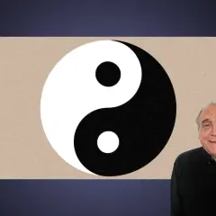 En man ler bredvid en yin och yang-symbol.