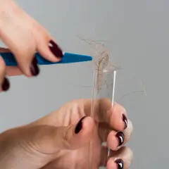 Hårstrån samlas i ett provrör, kanske för ett allergi test.