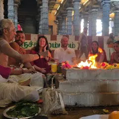 En präst leder en grupp människor i en eldceremoni, en form av puja. Vad betyder puja? Det är en hinduisk ritual för att visa vördnad.
