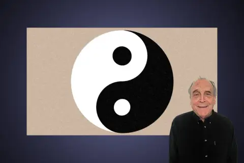 En man ler bredvid en yin och yang-symbol.