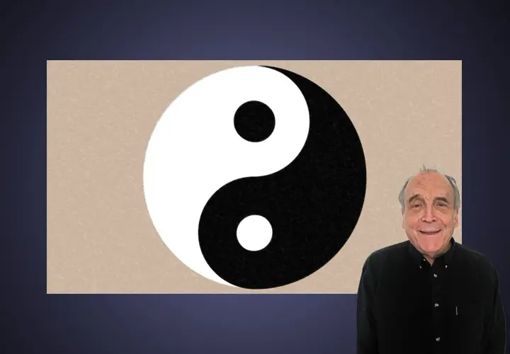 En man ler bredvid en yin och yang-symbol.