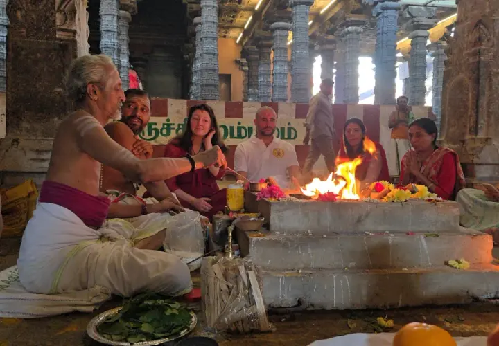En präst leder en grupp människor i en eldceremoni, en form av puja. Vad betyder puja? Det är en hinduisk ritual för att visa vördnad.