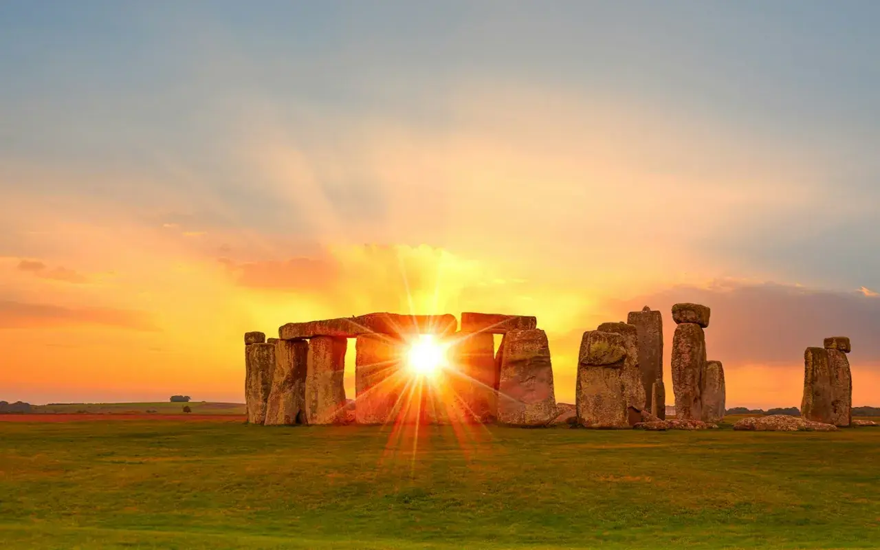 Solens strålar bryter igenom Stonehenge, en magisk syn för att fira vintersolståndet.