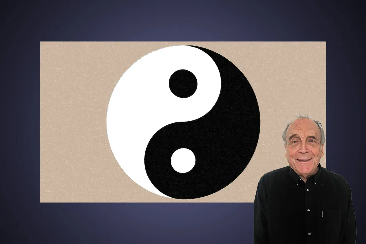 En man ler bredvid en yin och yang-symbol.