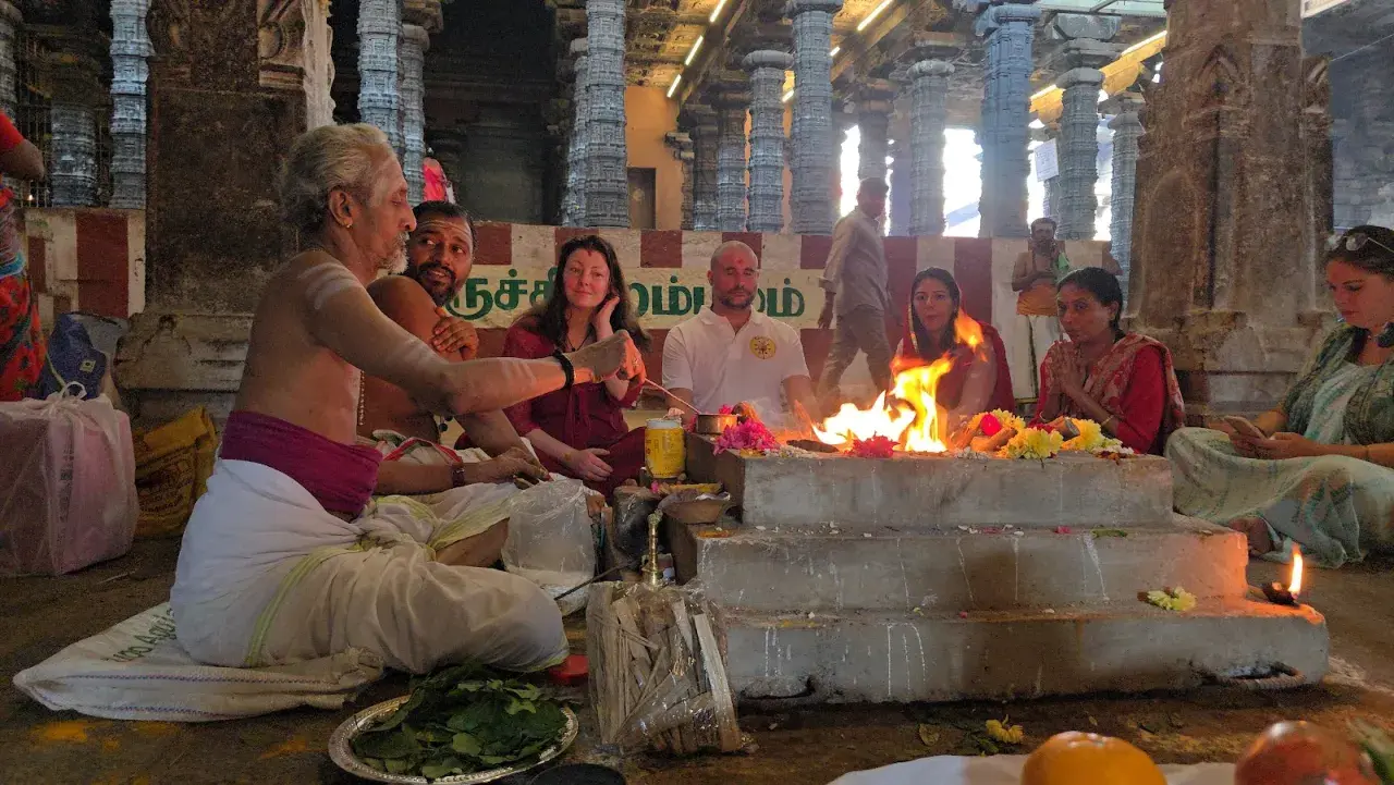 En präst leder en grupp människor i en eldceremoni, en form av puja. Vad betyder puja? Det är en hinduisk ritual för att visa vördnad.