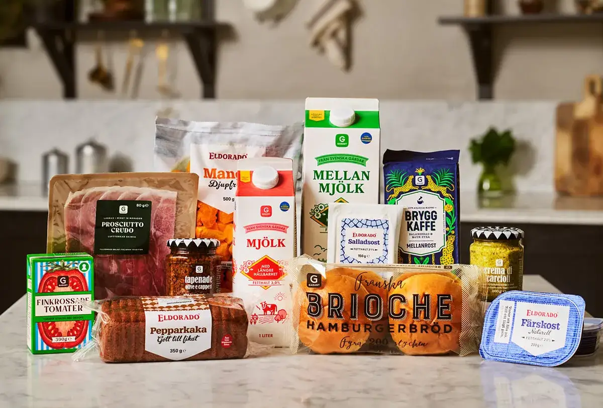 En härlig samling eko matprodukter: prosciutto, mjölk, kaffe, bröd och mer. Perfekt för en god måltid.