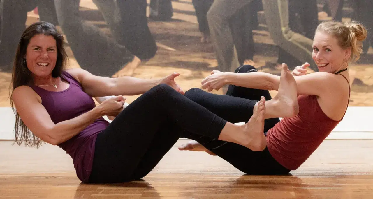 Tv&aring; kvinnor g&ouml;r yoga tillsammans, en &ouml;vning som kan vara bra f&ouml;r klimakteriet.